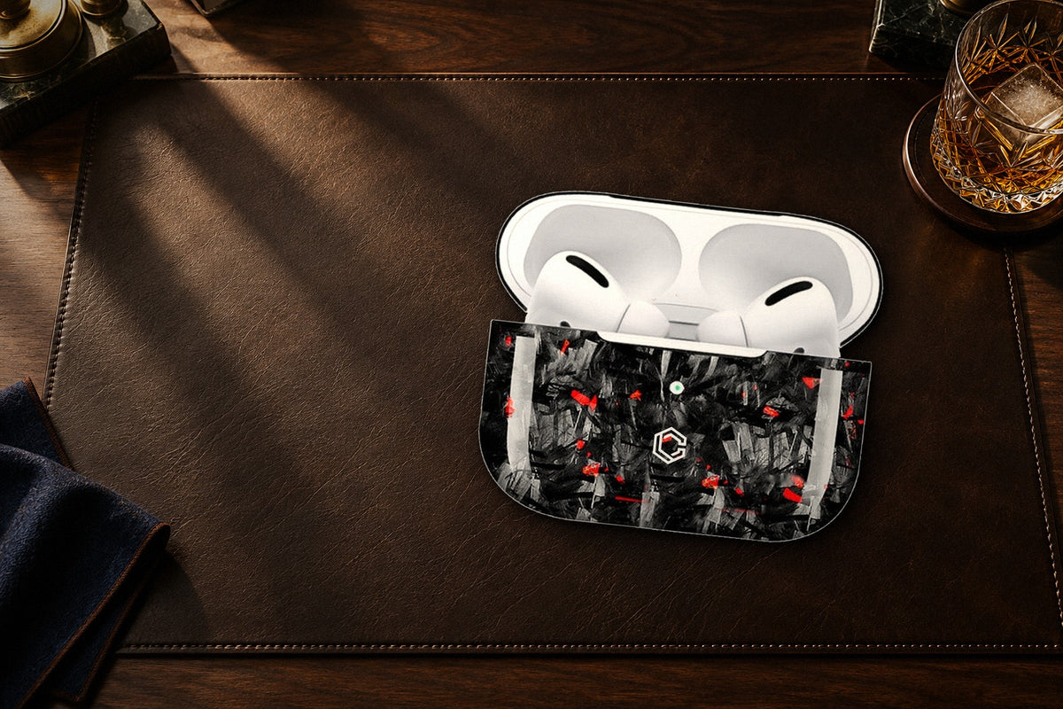 Carboluxe forged carbon AirPods case on a leather desk