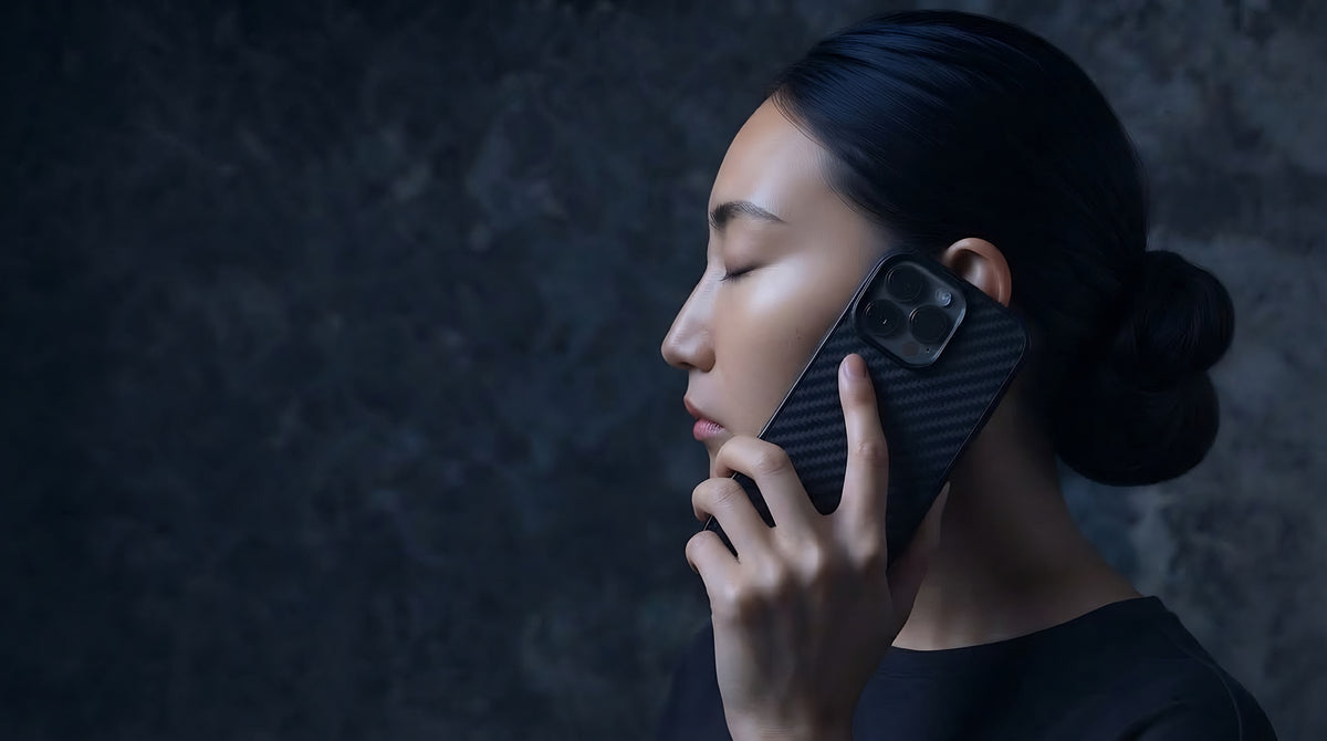 Woman holding a phone in a Carboluxe carbon fiber case to her ear