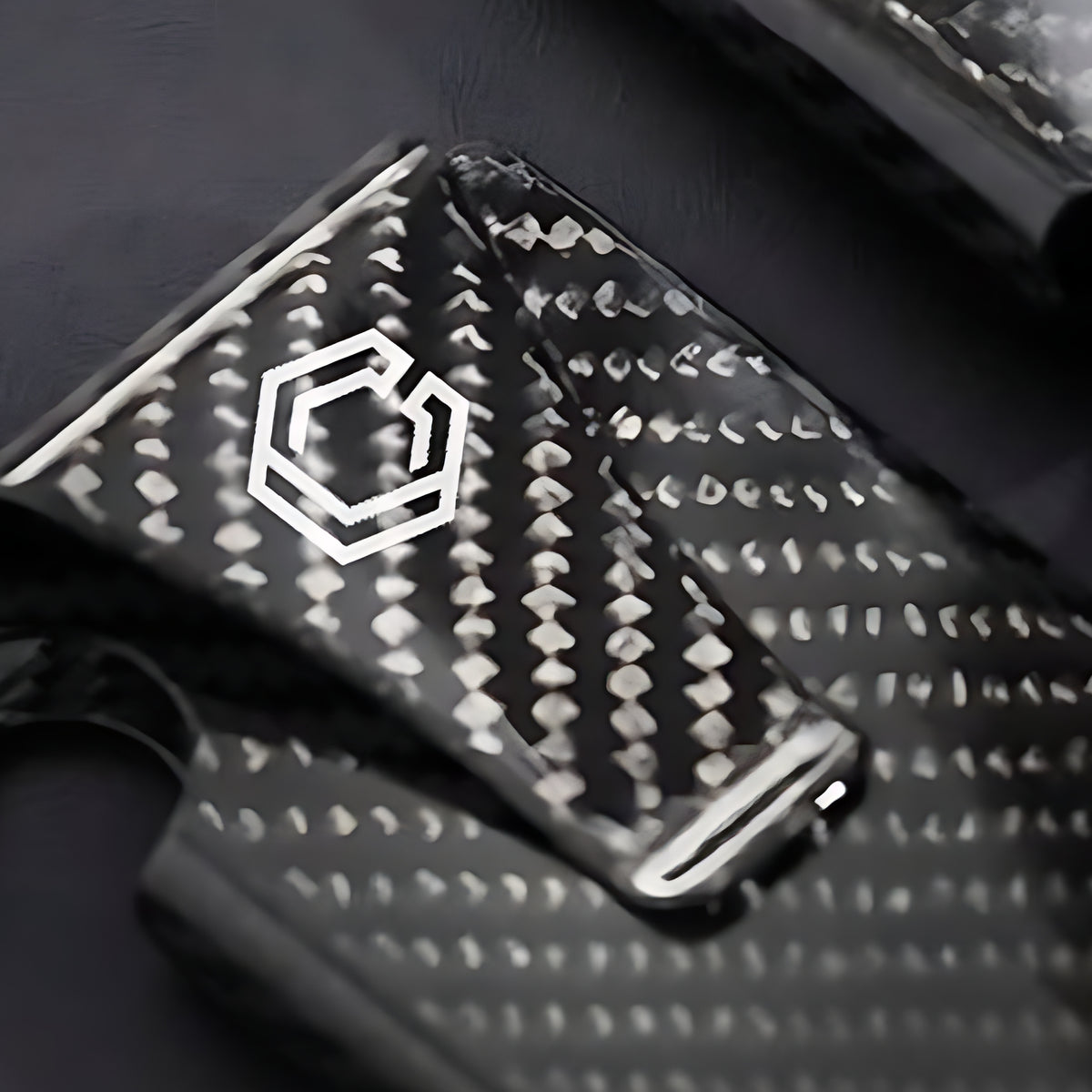 Close-up of Carboluxe carbon fiber weave and logo on wallet clip