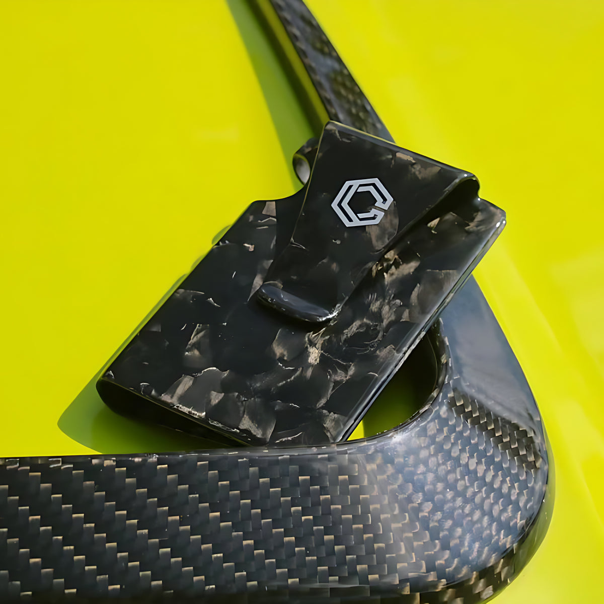 Carboluxe forged carbon fiber wallet on a yellow car